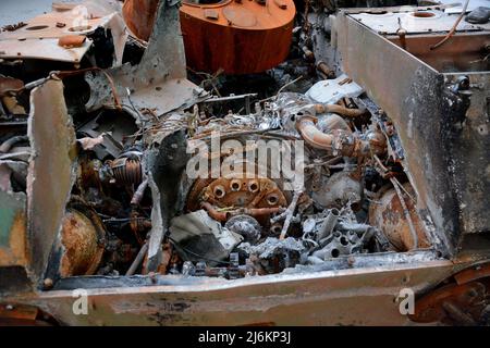 Region Kiew, Ukraine - 02. Mai 2022, Nahaufnahme des Motors eines zerstörten russischen Panzers am Straßenrand gesehen, wurde er vom ukrainischen Militär in der Region Kiew zerstört. Russland marschierte am 24. Februar 2022 in die Ukraine ein und löste damit den größten militärischen Angriff in Europa seit dem Zweiten Weltkrieg aus Stockfoto