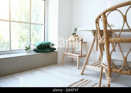 Holztreppe mit Tisch und Korbsessel im Innenraum des Raumes Stockfoto