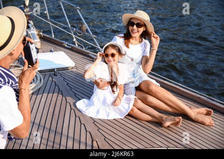 Glückliche junge Familie, die sich auf der Yacht ausruht Stockfoto