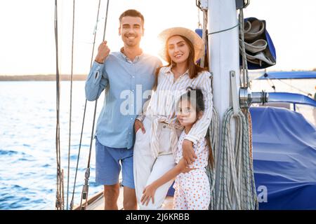 Glückliche junge Familie, die sich auf der Yacht ausruht Stockfoto