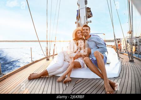 Glückliche junge Familie, die sich auf der Yacht ausruht Stockfoto