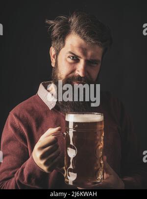 Älterer Mann trinkt Bier mit Überraschungsgesicht. Biersorten und -Stile. Retro-Mann mit einem Bier. Mann mit Bierkrug. Stockfoto