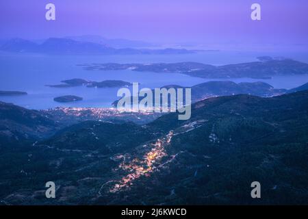 Kleines Dorf in den Bergen und Stadt am Meer kosten in der Nacht Stockfoto