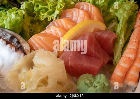 Obere und Nahaufnahme der Sashimi-Platte, Lachs-, Thunfisch-, Shrimps- und Saba-Fisch-Scheiben. Stockfoto