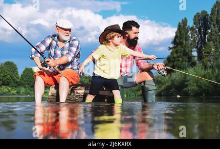 Angeln wurde zu einer beliebten Freizeitbeschäftigung. Großvater mit Sohn und Enkel, der Spaß im Fluss hat. Hobby für Männer. Familie Fischer Angeln mit Stockfoto