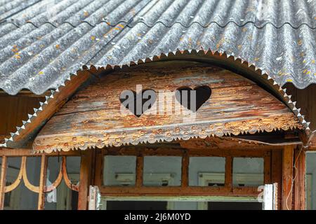 Außenansicht des alten Hauses im Dachgeschoss. Geschnitzte Herzen in das Holz Stockfoto