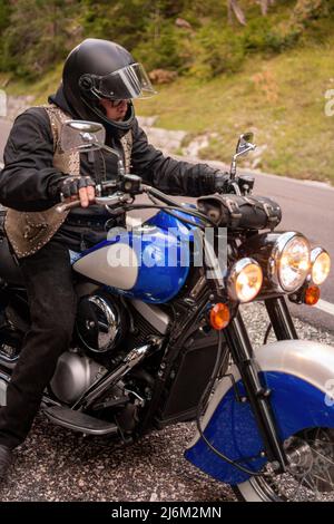 Kerl auf Retro-Cruiser-Motorrad auf Bergstraße in Südtirol Stockfoto