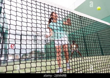 Frau spielt Paddle Tennis, konzentrieren Sie sich auf das Netz Stockfoto