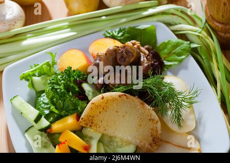 Salat mit Hühnerherzen und gebratenem Käse Stockfoto