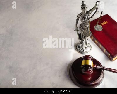 Symbole der amerikanischen Gerechtigkeit - eine Figur der Göttin der Gerechtigkeit - Themis, ein Richtergavel und ein Buch - die Heilige Bibel auf weißem Hintergrund. Niedrig an Stockfoto