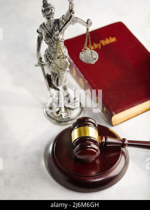 Nahaufnahme. Ein hölzerner Gavel eines Richters, eine Bronzefigur der Göttin Themis und ein Buch - die Heilige Bibel. Freiheit, Demokratie, Gerechtigkeit, Rechtsstaatlichkeit. Ad Stockfoto