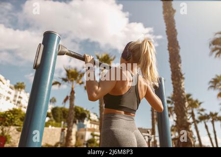 Junge Fitness-Frau macht Übungen im Park Stockfoto