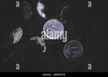 Münze im Boden. Geld auf dem Boden verstreut. Die Abwertung des Rubels. Der Fall der Währung. Änderung des Wechselkurses. Stockfoto