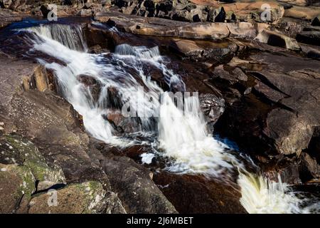Schöner Wasserfall umgeben von Felsen und Platten bei Reinsfoss in Nissedal, Telemark, Norwegen, Skandinavien. Stockfoto