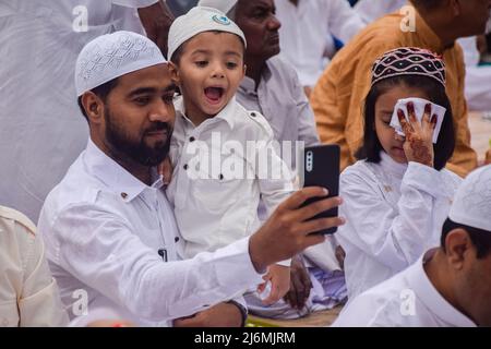 3. Mai 2022, Rajpur Sonarpur, Westbengalen, Indien: Ein Mann macht ein Selfie mit einem Jungen, bevor er an Eid al-Fitr-Gebeten teilnimmt, um das Ende des heiligen Fastenmonats Ramadan an der Roten Straße in Kalkata zu markieren. (Bild: © Sankhadeep Banerjee/ZUMA Press Wire) Stockfoto