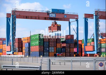 27. April 2022, Hamburg: Auf dem Gelände des HHLA Container Terminal Altenwerder (CTA) wird ein Container verladen. Foto: Jonas Walzberg/dpa Stockfoto