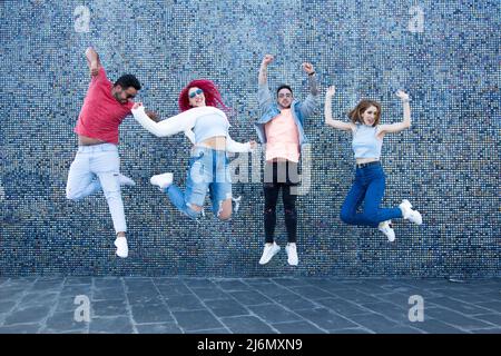 Eine Gruppe von vier jungen Freunden, die springen Stockfoto