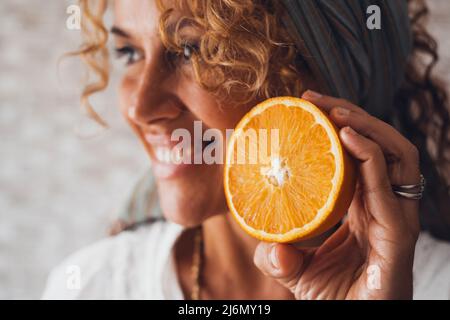 Orange Früchte und glücklich Erwachsene junge hübsche Frau Porträt lächelnd im Hintergrund defokussed. Konzept von Wohlbefinden und gesunder Lebensführung. Vitamin c
