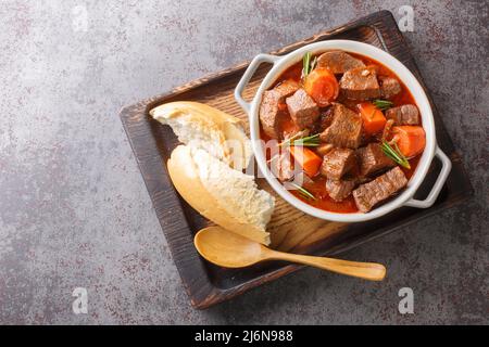 Daube de Boeuf Provencale langsam gegartes, reichhaltiges Rindereintopf aus der Nähe in das Holztablett auf dem Tisch. Horizontale Draufsicht von oben Stockfoto