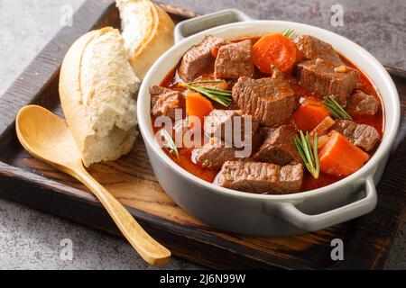 Daube de Boeuf Provencale langsam gegartes, reichhaltiges Rindereintopf aus der Nähe in das Holztablett auf dem Tisch. Horizontal Stockfoto