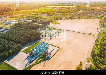 Erhöhte Ansicht von oben moderner Kornspeicher, Korntrocknungskomplex, kommerzielles Getreide- oder Saatsilos in der ländlichen Landschaft des sonnigen Frühlings. Silos Für Maistrockner, Binnengetreide Stockfoto