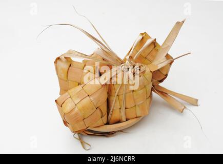 Ketupat Reisdumpling Spezialgericht serviert im Eid Mubarak. Ketupat isoliert auf weißem Hintergrund. Ketupat ist gekochter Reis mit jungen Kokosnussblättern Casin Stockfoto