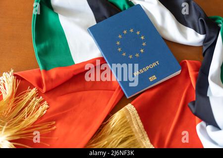 Reisepass und eine Flagge der Vereinigten Arabischen Emirate auf einem hölzernen Hintergrund. Reisekonzept. Stockfoto