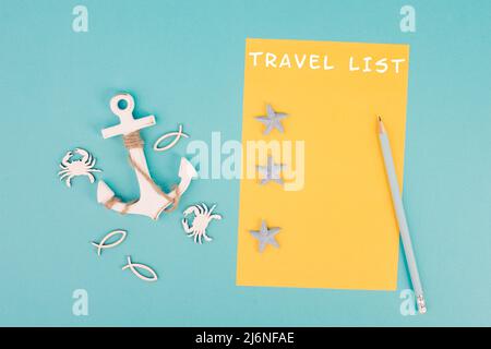 Reiseliste steht auf dem gelbfarbenen Papier, ankert mit Fischsternen und Krabben, Ferienplan und Destination, Urlaub und Lifestyle-Koncep Stockfoto