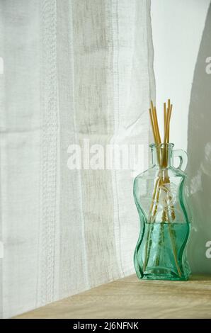 Glasflasche mit Raumduft und Bambusdiffusorstäben Stockfoto