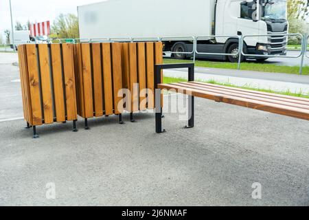 Bank und Mülltonnen im städtischen Raum Stockfoto