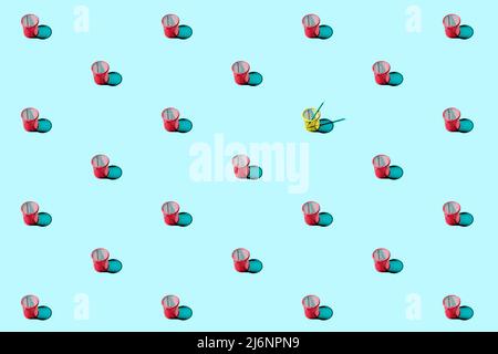 Einfaches, sich wiederholendes Muster aus roten Mesh-Stiftsbechern auf blauem Hintergrund. Stockfoto
