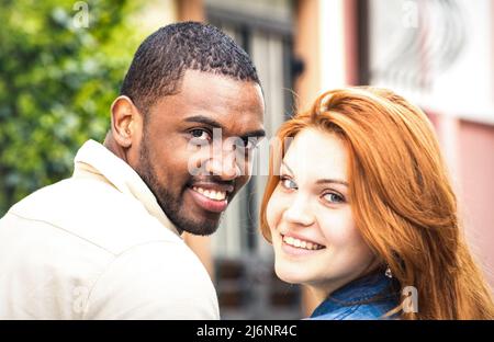 Portrait eines multiethnischen Mannes und einer jungen Frau, die im Freien gehen - glückliches multirassisches Paar zu Beginn der Liebesgeschichte - Integrationskonzept mit einem Freund Stockfoto