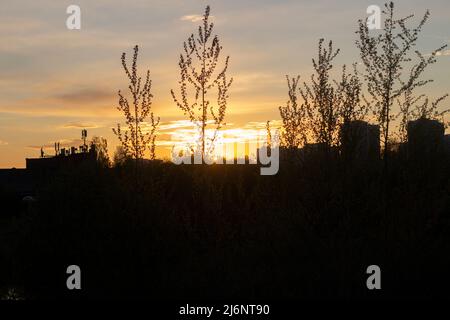 Sonnenuntergang in der Stadt. Die Sonne untergeht über dem Horizont. Einbruch der Dunkelheit. Stockfoto