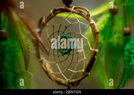 Dreamcatcher im Innenraum. Details des indischen Amuletts für guten Schlaf. Objekt aus Fäden gewebt. Symbol des Friedens im Haus. Dekoration im Zimmer. Stockfoto