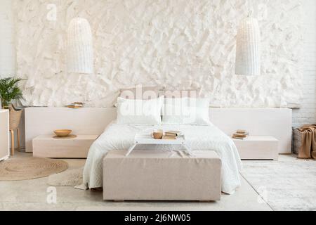 Gemütliches Bett Im Modernen Schlafzimmer Mit Weißen Wänden Und Möbeln Stockfoto