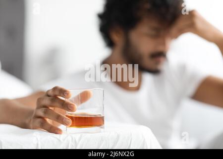 Glas mit Alkohol in bärtiger dunkelhäutiger Guy-Hand Stockfoto