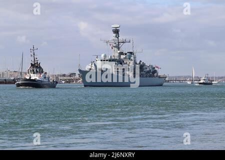 Die Royal Navy Typ 23 Fregatte HMS WESTMINSTER wird vom Marinestützpunkt aus zur Hafenmündung begleitet Stockfoto