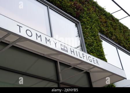 Nahaufnahme des Eingangs zum Tommy Hilfiger Bekleidungsgeschäft im Ashford Outlet Center, Kent, Großbritannien. Stockfoto