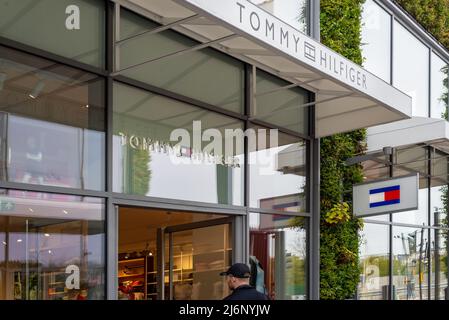 Eingang des Einzelhandelsgeschäften Tommy Hilfiger im Ashford Outlet Center, Kent, England, Großbritannien. Stockfoto