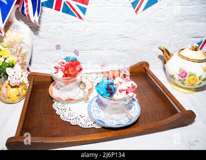 Queen Elizabeth II Platinum Jubilee Cream Sundae Street Party Food rot-weißes und blaues Eis mit Feier Union Jack Food Toppers auf einem w Stockfoto