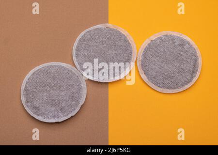 Draufsicht der Kaffeepads auf orangefarbenem und braunem Karton. Flache Lay-Komposition Stockfoto