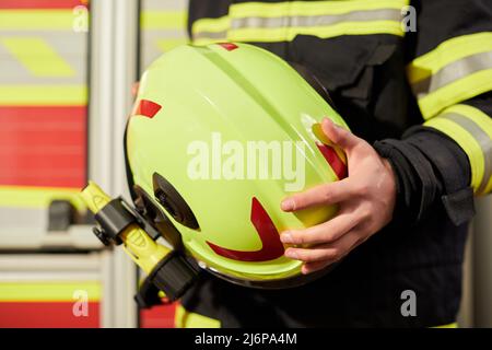 Nahaufnahme des Helms eines Feuerwehrmann. Feuerwehrmann mit gelbem Helm Stockfoto