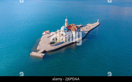 Drohnenansicht der künstlichen Insel der Kirche unserer Lieben Frau von den Felsen an den Ufern von Perast in der Bucht von Kotor, Montenegro Stockfoto
