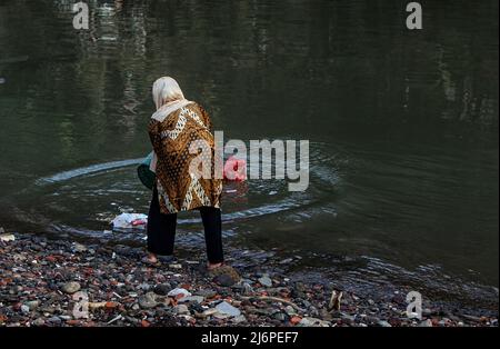 Am 2. Mai 2022 wird eine Frau gesehen, wie sie Müll in den Cisadane-Fluss in Bogor, West-Java, Indonesien, wirft. Die Anwohner werfen Plastikmüll aus Hausmüll in den Fluss, weil die Öffentlichkeit nicht über die Bedeutung einer sauberen und gut gepflegten Umwelt bewusst ist. (Foto von Adriana/INA Photo Agency/Sipa USA) Stockfoto