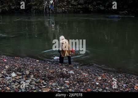 Am 2. Mai 2022 wird eine Frau gesehen, wie sie Müll in den Cisadane-Fluss in Bogor, West-Java, Indonesien, wirft. Die Anwohner werfen Plastikmüll aus Hausmüll in den Fluss, weil die Öffentlichkeit nicht über die Bedeutung einer sauberen und gut gepflegten Umwelt bewusst ist. (Foto von Adriana/INA Photo Agency/Sipa USA) Stockfoto