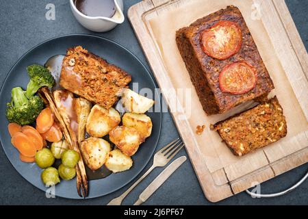 Vegane Nussbraten / Nusskuchen auf einem Holzbrett mit einem Nussbraten Abendessen. VEREINIGTES KÖNIGREICH Stockfoto