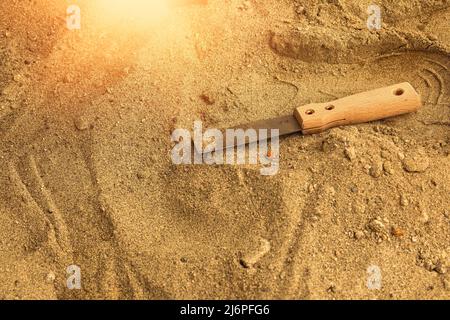 Skelett und archäologische Werkzeuge im Sand.Graben nach Fossilien. Stockfoto