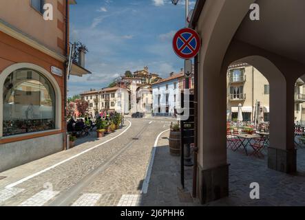 Monforte d'Alba, langhe, Italien - 02. Mai 2022: Mittelalterliches Dorf Monforte d'Alba auf dem Hügel von den Arkaden der Via Vallada aus gesehen Stockfoto