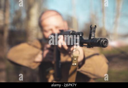 Schnauze eines Maschinengewehrs aus der Nähe in den Händen eines Mannes Stockfoto