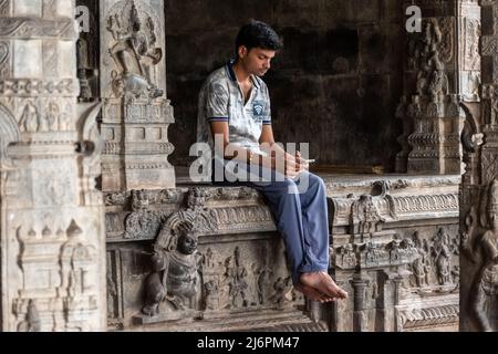 Vellore, Tamil Nadu, Indien - 2018. September: Ein indischer Junge sitzt allein in einem alten Hindu-Tempel am Vellore Fort. Stockfoto